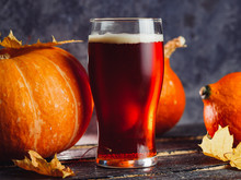 A Glass Of Pumpkin Ale On A Wooden Table