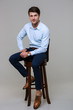 © Drobot Dean - Full length portrait of happy young businessman sitting on chair