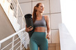 © Drobot Dean - Smiling fit young sportsgirl walking down a staircase