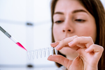 Canvas Print - Young woman fill PCR microtubes with dispenser