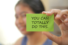 Blurry Image Of Young Girl Holding A Motivation Sign With Text On It - You Can Totally Do This.  Encouragement And Self Improvement Concept.
