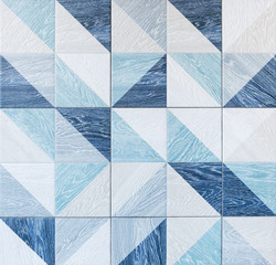 Modern ceramic tile with geometric pattern and imitation of wood texture in gray and light blue colors.