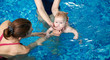 © anatoliy_gleb - Adorable baby boy enjoying swimming in paddling turquoise pool with his mother and instructor. Child swimming trainer in action. Sport and healthy development from first year of life. Cropped view