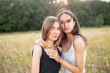 © Dima Aslanian - Two adorable young women hugging on the field. Best friends