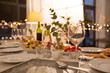 celebration, holidays, catering and eating concept - table served with plates, wine glasses and food for home dinner party