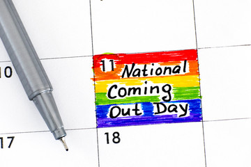 Reminder National Coming Out Day in calendar with pen.