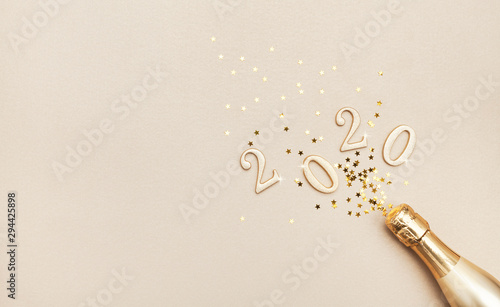 Fotografía Creative Christmas and New Year composition with golden champagne bottle, confetti stars and 2020 numbers