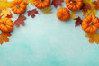 © juliasudnitskaya - Autumn Thanksgiving background. Pumpkins and maple leaves on turquoise table top view.