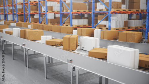 Fotografía Packages delivery, parcels transportation system concept, cardboard boxes on conveyor belt in warehouse