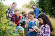 © Halfpoint - Group of school children with teacher on field trip in nature, learning science.