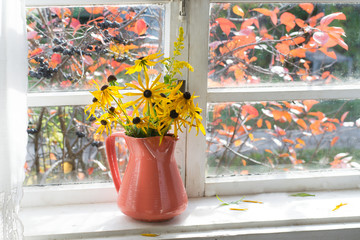 Wall Mural - bouquet of yellow flowers in vase on windowsill