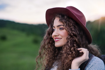 Wall Mural - close-up portrait of young woman traveller standing in nature.