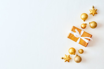 Wall Mural - Flat lay christmas border with gold christmas balls and gift box on a white background