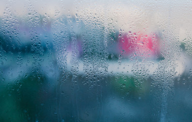 Moist word written on wet window. High level of dampness in apartment. Window glass with high air humidity. Background of natural water condensation