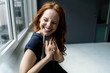 © Westend61 - Portrait of laughing redheaded businesswoman with digital tablet in a loft