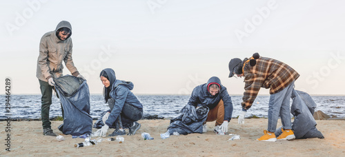 Fotomural Panoramic shot of young students volunteers that cleaning up plastic on the beac