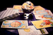 Tarot cards spread on a table surrounding crystal ball