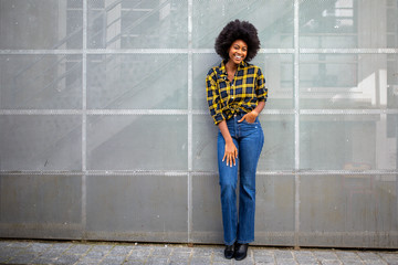 Wall Mural - Full body stylish young african american woman with afro smiling