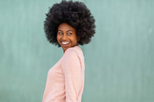 Happy Young Black Woman With Afro Hair Against Green Background Glancing