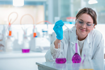 Wall Mural - young medical technologist female making testing with test tube while doing research in science labo