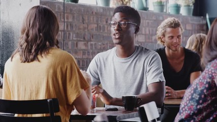 Wall Mural - Young Couple Meeting Sitting At Table In Coffee Shop And Talking