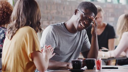 Wall Mural - Young Couple Meeting Sitting At Table In Coffee Shop And Talking