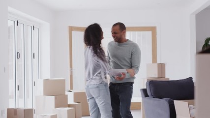 Wall Mural - Loving Couple Dancing Together As They Celebrate Moving Into New Home 