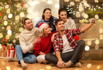 Sticker - celebration and holidays concept - happy friends with glasses celebrating christmas at home party and taking selfie by smartphone