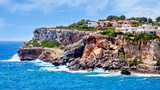 Fototapeta Miasto - Houses on cliffs around beautiful beach, Cala Llombards in Mallorca, turquoise water and blue sky, Balearic Island, Spain