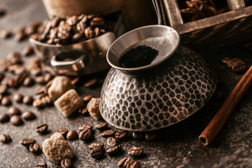 Coffee cup and coffee beans on dark stone background.