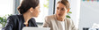 © LIGHTFIELD STUDIOS - panoramic shot of two businesswomen in formal wear talking in office