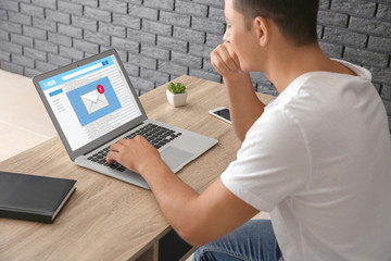 Young man working with laptop while sitting at table