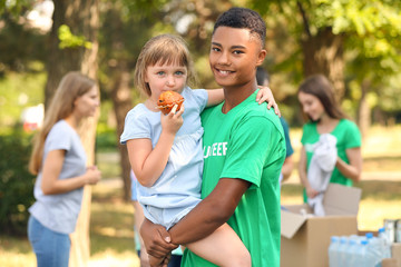 Wall Mural - African-American volunteer with poor little girl outdoors