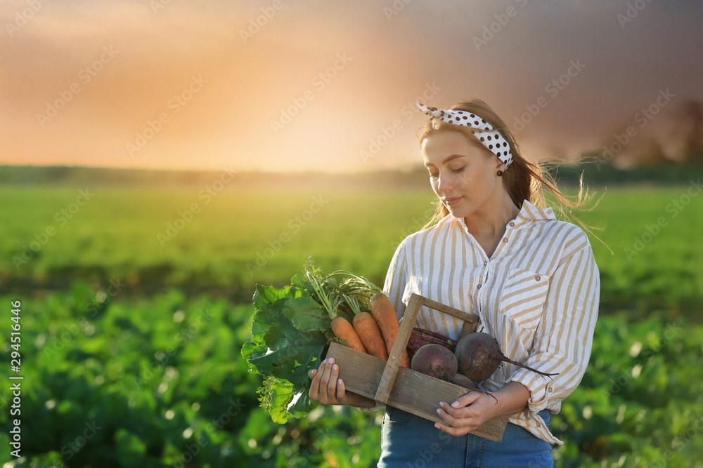 Female farmer with gathered vegetables in field