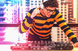 © Mongkolchon - young music DJ with headphone playing turntable control music mixing in private club