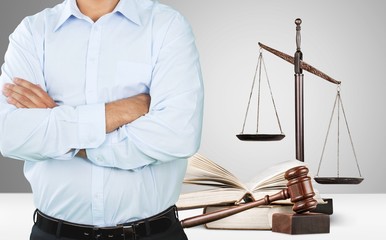 Canvas Print - Lawyer standing with crossed arms, Scales of Justice on the background