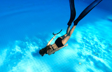 Wall Mural - Underwater images of women diving deep