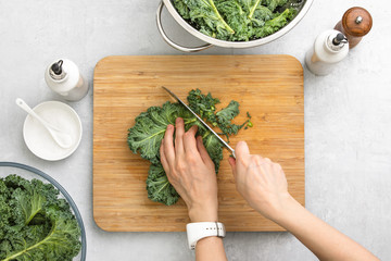 Wall Mural - Top down view of fresh kale leaves cut on a cutting board