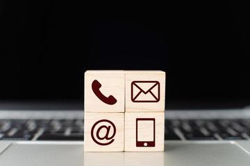 Fototapete - Wood block symbol telephone, mail, address and mobile phone on laptop keyboard. Website page contact us or e-mail marketing concept