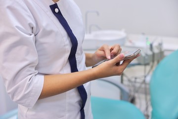 Close up of female doctors hand with mobile phone smartphone