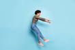 Oh my god. Full length photo of dark skin wavy lady jumping high blown away by strong stormy wind confused wear casual outfit isolated pastel blue color background