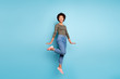 © deagreez - Full length body size photo of charming cute nice girlish childish black youngster jumping spending her free time in jeans denim footwear smiling toothily isolated blue vivid color background