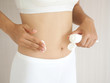 © jaojormami - weight loss and slim body in woman and she applying cream on her belly skin and cause of fatty use for anti cellulite and body firming gel or moisturizer and lotion product on white background.
