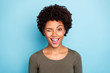Close up photo of cheerful candid afro american girl wink blink have free time with her friends wear green casual clothes isolated over blue color background