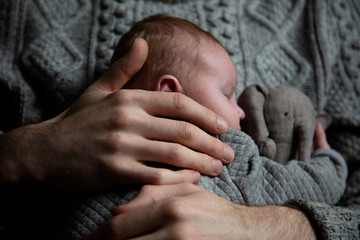 A father holding his baby son on his chest. Family bonding. Fatherhood