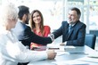 © opolja - Business people shaking hands, finishing up a meeting.