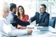 © opolja - Business people shaking hands, finishing up a meeting.
