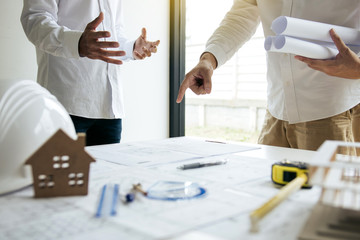 Wall Mural - Team architect or engineering people standing working discussion together at a construction site.