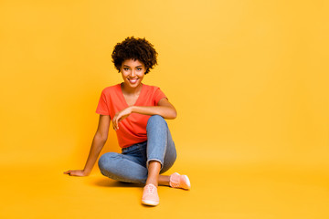 Poster - Portrait of positive charming cheerful girl sit have free time enjoy rest relax weekends wear casual style clothes sneakers isolated over yellow bright color background