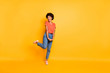 © deagreez - Full length body size photo of curly wavy cheerful charming cute nice lady rejoicing with sales she sees nearby wearing jeans denim isolated over yellow vivid color background